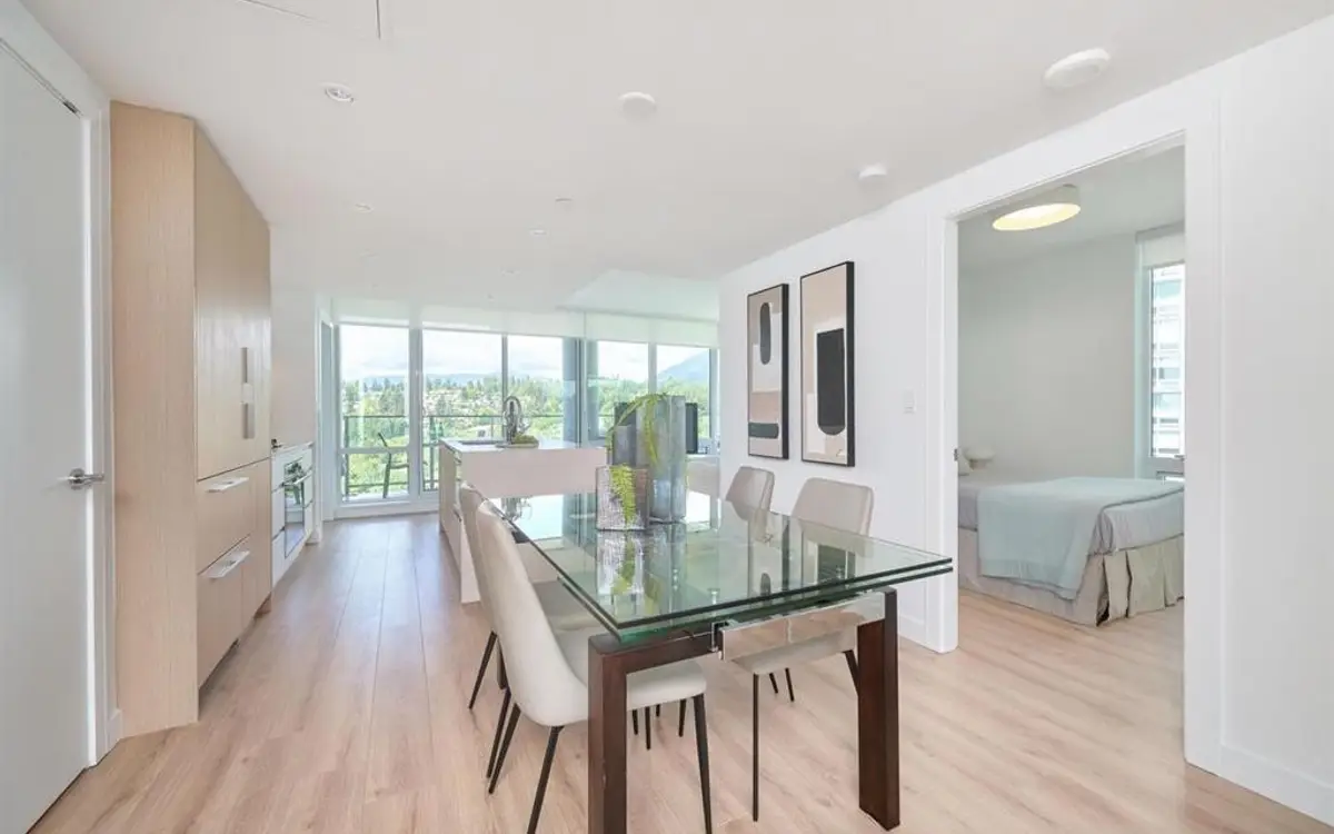 Dining room with a glass table opening through to a bedroom beyond