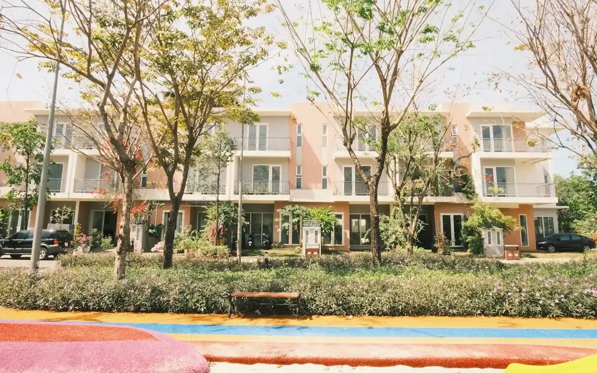 Row of modern townhomes with young trees and landscaped frontage