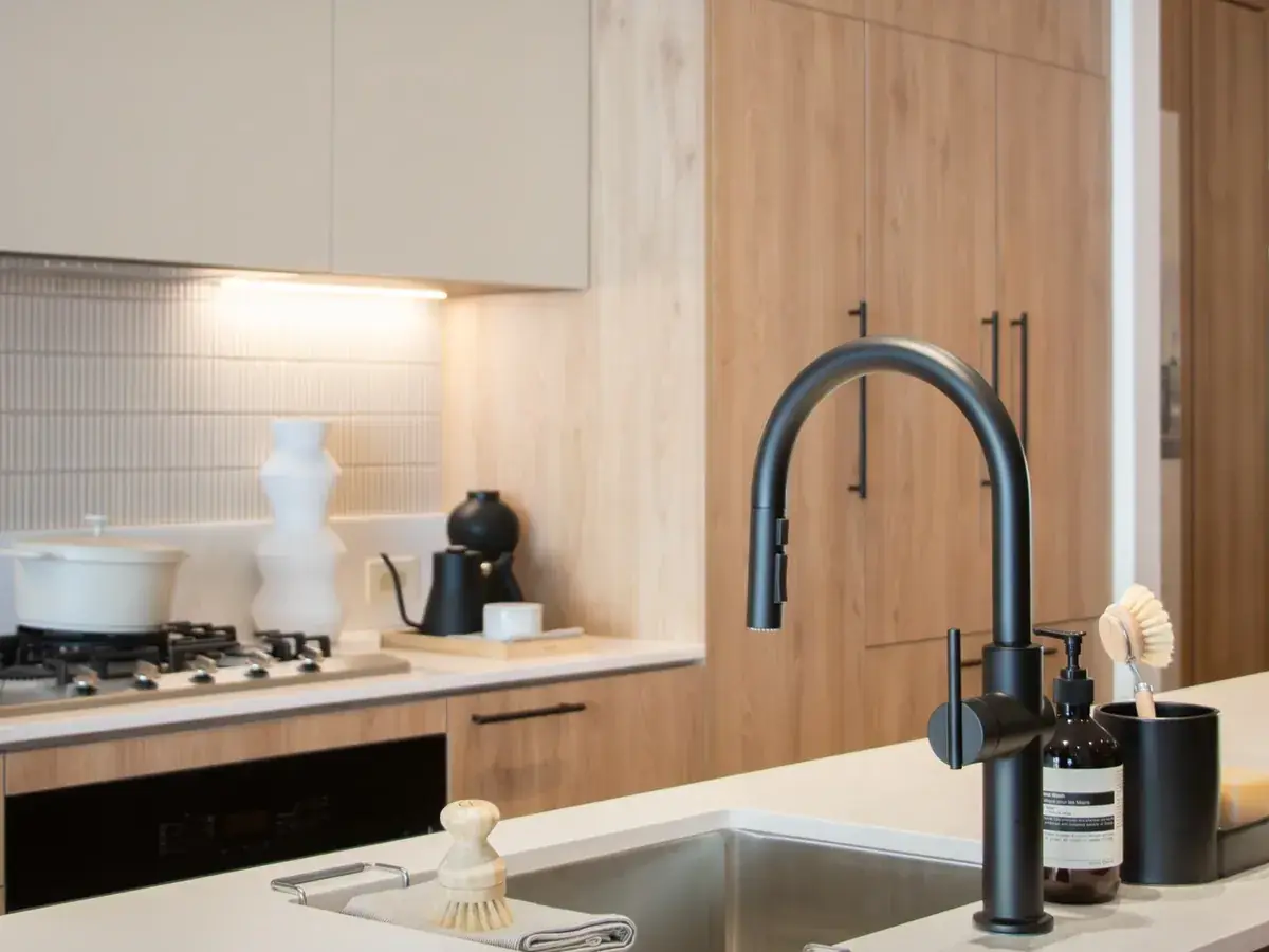 Designer kitchen at the WREN presentation centre with light wood cabinetry and matte black fixtures